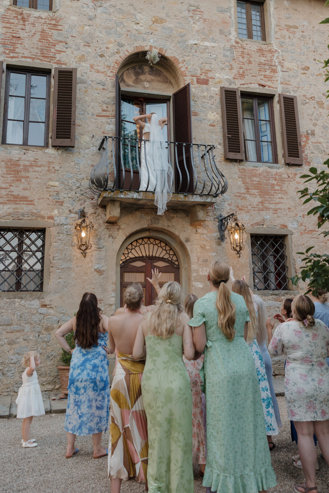 dreamy bouquet toss of a tuscan balcony captured by California wedding photographer Kassidy Klicks