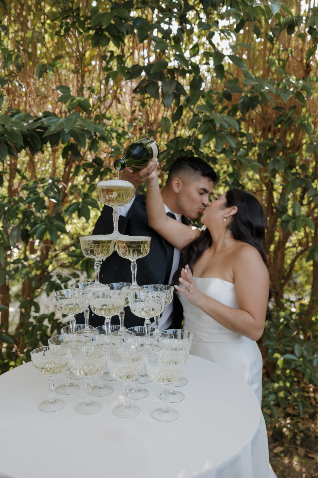 Bride and groom champagne tower pour by Timeless wedding photographer Kassidy Klicks