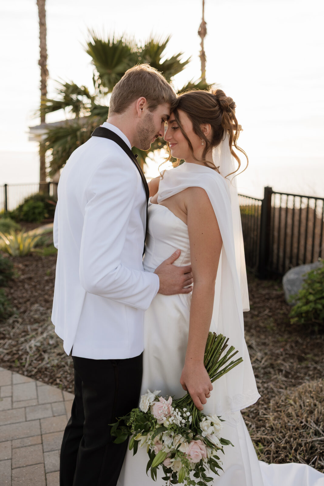 Wedding photo captured in true-to-life colors showing bride and groom on their cliffside wedding day in Pismo Beach, California, by Southern California wedding photographer