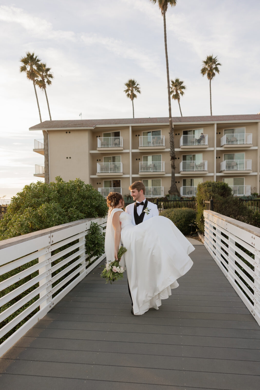 Bride and groom sharing a romantic moment together on the cliffs overlooking the ocean in Pismo Beach, California, captured by Southern California wedding photographer
