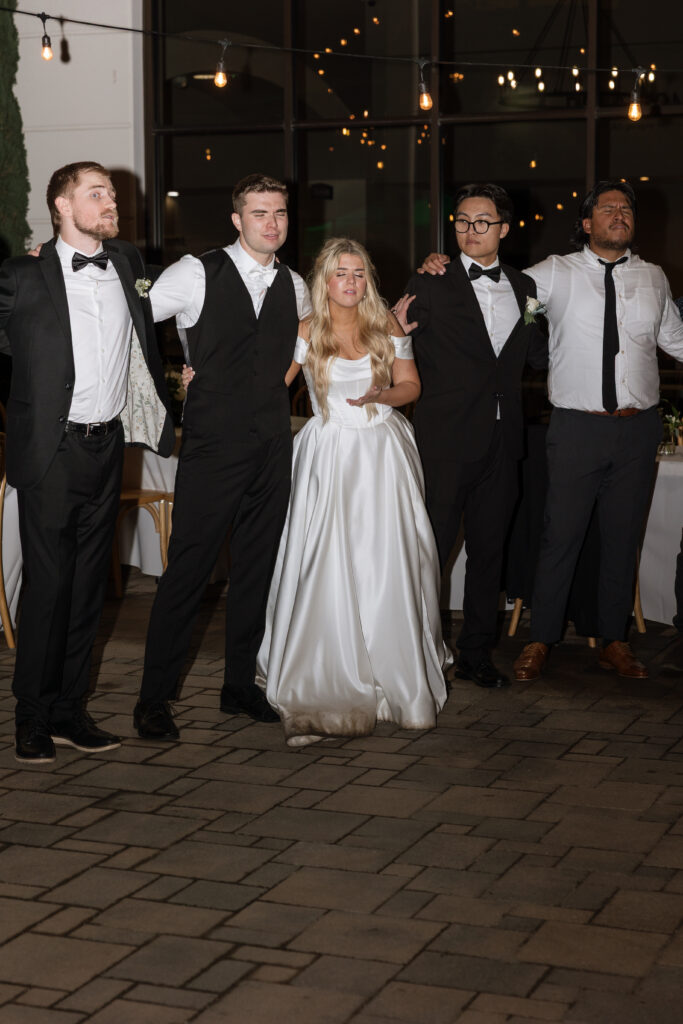 Bride and groom surrounded by family and friends for worship as last wedding song to end the night in Southern California