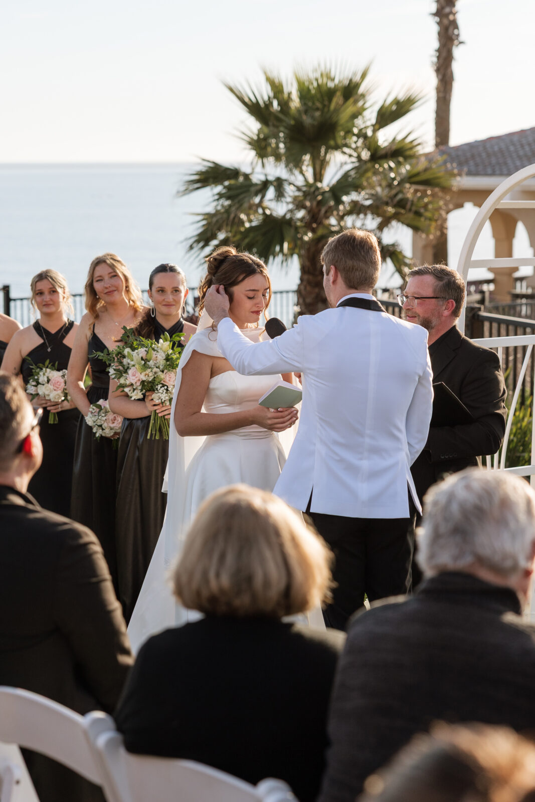 Bride reading her vows during cliffside wedding ceremony in Pismo Beach, California, emotional candid moment captured by Southern California wedding photographer