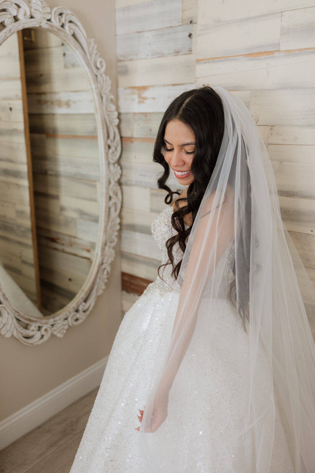 Bride Chelsea getting ready for her wedding day at Serendipity Garden in Oak Glen, California, preparing in her bridal suite