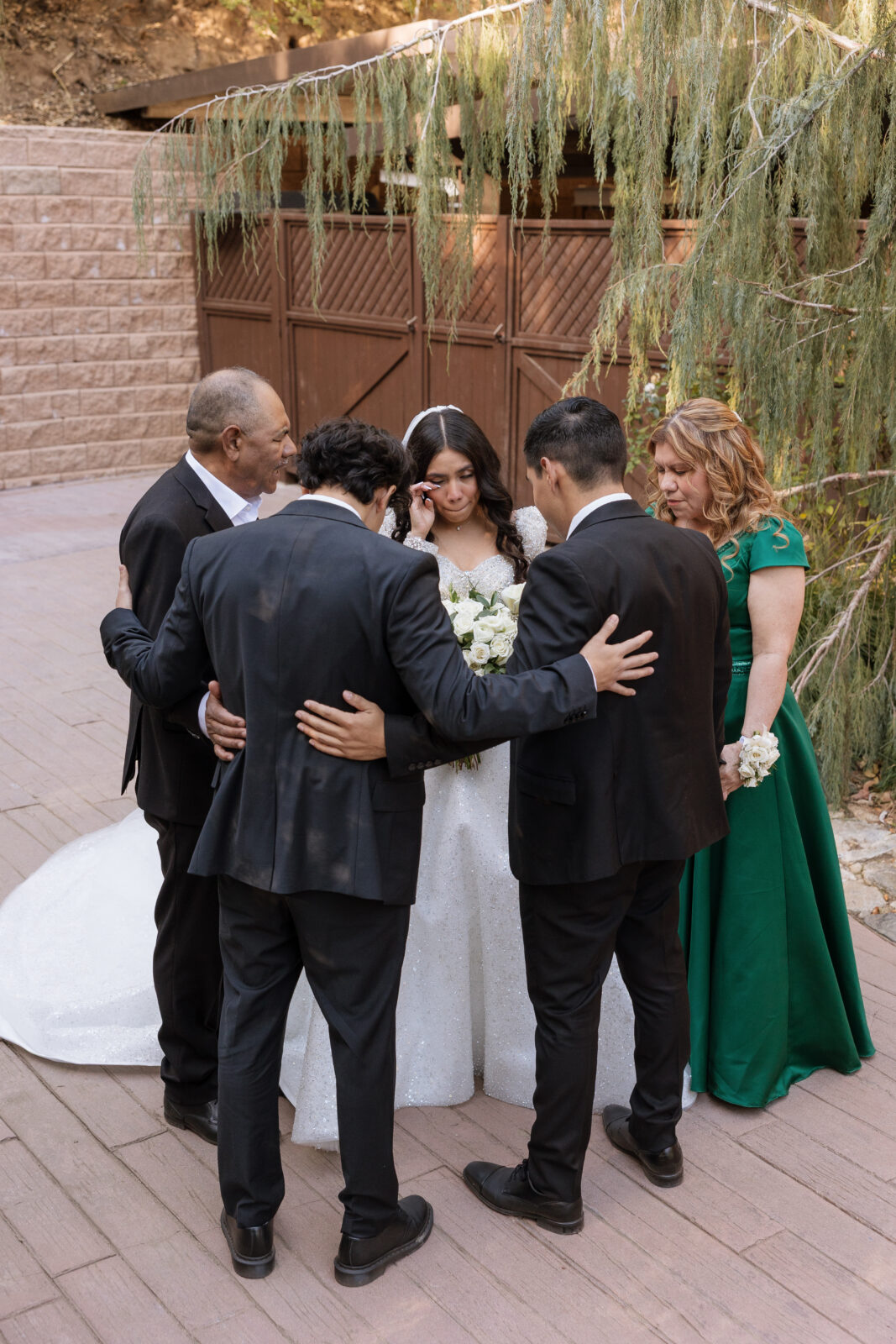 Bride Chelsea surrounded by family praying over her before the ceremony at Serendipity Garden in Oak Glen, California, faith-filled wedding moment