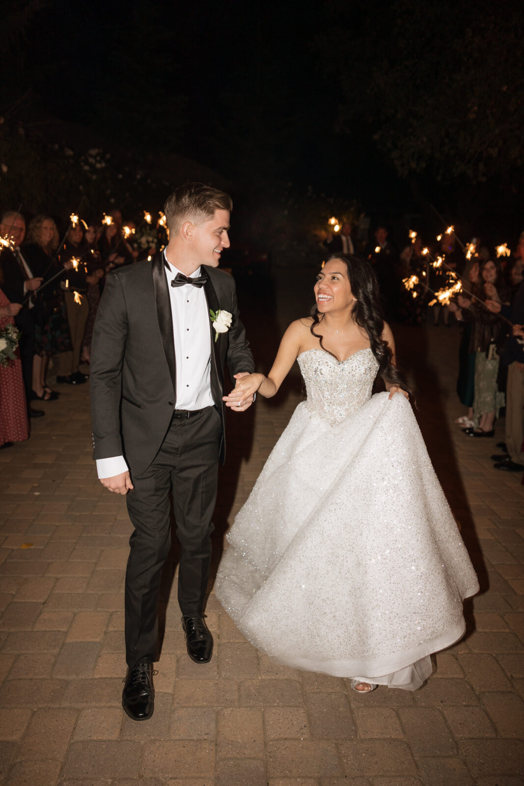Bride and groom Chelsea and Blake celebrating their wedding with a sparkler exit at Serendipity Garden in Oak Glen, California, golden evening wedding moment
